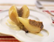 Nahaufnahme einer geschnittenen gefüllten Birne mit Sauce auf dem Teller — Stockfoto