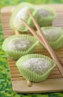 Green tea Mochis on wooden mat with wooden sticks — Stock Photo