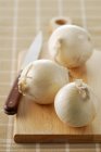 White onions on board — Stock Photo