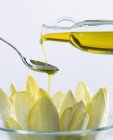 Aceite de oliva y achicoria en un recipiente de vidrio - foto de stock