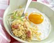 Fried egg with wheat and diced bacon — Stock Photo