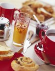 Continental breakfast with dishes and glasses over table — Stock Photo