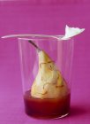 Poached pear with saffron in glass over purple background — Stock Photo
