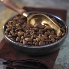Granos de café en plato negro - foto de stock
