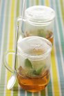 Vue rapprochée de deux tasses en verre avec des infusions de thé — Photo de stock