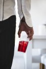 Vue rapprochée de l'homme tenant une boisson glacée rouge — Photo de stock