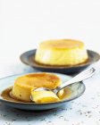 Crème Caramel auf Tellern mit Löffel — Stockfoto
