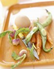 Pelare le verdure su vassoio con coltello — Foto stock