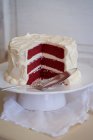Gâteau en velours rouge sur un support à gâteau, tranché — Photo de stock