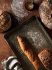 Vari pani di pane in stagno e su superficie di legno — Foto stock