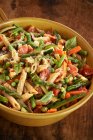 Penne with spring vegetables and cheese in large bowl — Stock Photo