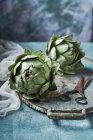 Still life of artichokes with knife — Stock Photo