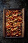 Roasted vegetables (carrots, potatoes) on a baking tray — Stock Photo