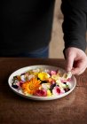 Человек делает съедобный цветочный салат — стоковое фото