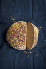 Pagnotta di pane integrale condita con fiori commestibili secchi, tagliata a fette — Foto stock
