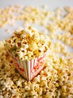 Popcorn in una ciotola di vetro su sfondo bianco — Foto stock
