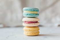 Three stacked colorful macarons on table — Stock Photo