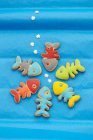 Fish shaped biscuits with colorful icing on blue background - foto de stock