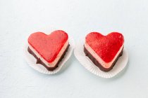 Duas tortas de creme de morango em forma de coração em um fundo branco — Fotografia de Stock