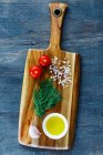 Bäuerlicher Küchentisch aus Holz mit Schneidebrett und Zutaten auf Vintage-Hintergrund — Stockfoto
