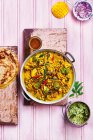Couve-flor e couve-flor romanesca curry com grão de bico, pimenta, cebola, servido com arroz, pães, manga e cebola crua — Fotografia de Stock