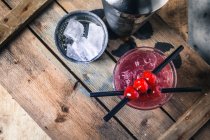 Singapore Sling cochtail with cherry liqueur, cherries and ice — стокове фото