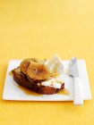 Rebanada de pan con miel, higos y queso ricotta con cuchillo en el plato - foto de stock