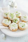 Kekse mit weißer Glasur, Limettenschale und Kokoskrümeln — Stockfoto