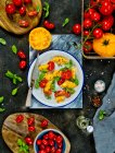 Una ensalada de tomates amarillos y rojos con albahaca - foto de stock