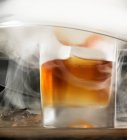 Cocktail à l'ancienne entouré de fumée — Photo de stock