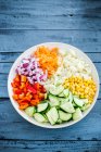 Verduras crudas picadas y maíz dulce en un tazón - foto de stock