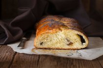 Pane dolce con semi di papavero, affettato su un pezzo di carta da forno — Foto stock