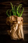 Green asparagus in a paper bag — Stock Photo