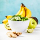 Zutaten für einen gesunden grünen Smoothie auf dem Tisch vor der blauen Wand — Stockfoto