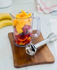 Ingredientes para um smoothie de frutas em um copo de medição — Fotografia de Stock