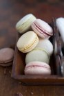 Various colourful macarons in wooden tray — Stock Photo