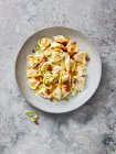 Tortellini with bacon, spring onions and creamy sauce — Stock Photo