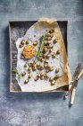 Baked meat with herbs on parchment paper with olive oil and thyme. — Stock Photo