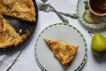 Fatia de um mascarpone e tarte de pêra, pêras verdes, xícara de chá — Fotografia de Stock