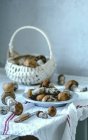 Os cogumelos frescos em uma cesta e em uma chapa — Fotografia de Stock