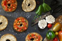 Вид сверху стола с итальянской брускеттой на хлеб фризелла со свежими помидорами, чесноком, оливковым маслом, солью и перцем — стоковое фото