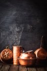 Verschiedene Arten von Vintage-Kupfer-Kochgeschirr vor dunklem Hintergrund — Stockfoto