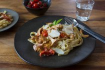 Tagliatelle with chanterelles and cherry tomatoes on plate — Stock Photo