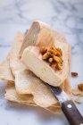 Two pieces of cheese with peanuts on thin flatbread — Stock Photo
