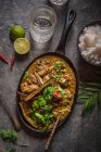 Curry rendang de ternera, cocinado lentamente con hierba de limón, hojas de lima, especias y crema de coco, adornado con berenjena crujiente y cilantro fresco - foto de stock