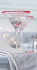 Ein Getränk, das über einem Weihnachtsbonbon in ein Martini-Glas gegossen wird — Stockfoto