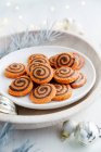 Swirls cookies on white plate in wooden bowl with decorations — Photo de stock