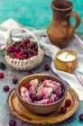 Sweet dumplings with cherries in wooden bowl — Stock Photo