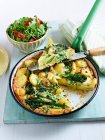 Фріттата з картоплею та брокколі та салатом у мисці — стокове фото