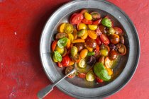 Томатный салат с оливками и базиликом в металлической миске — стоковое фото
